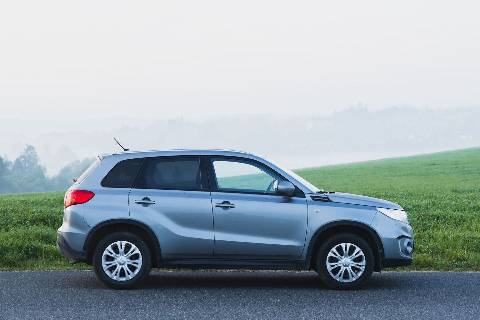 A silver SUV parked on a foggy countryside road in Zbraslavice, Czech Republic.